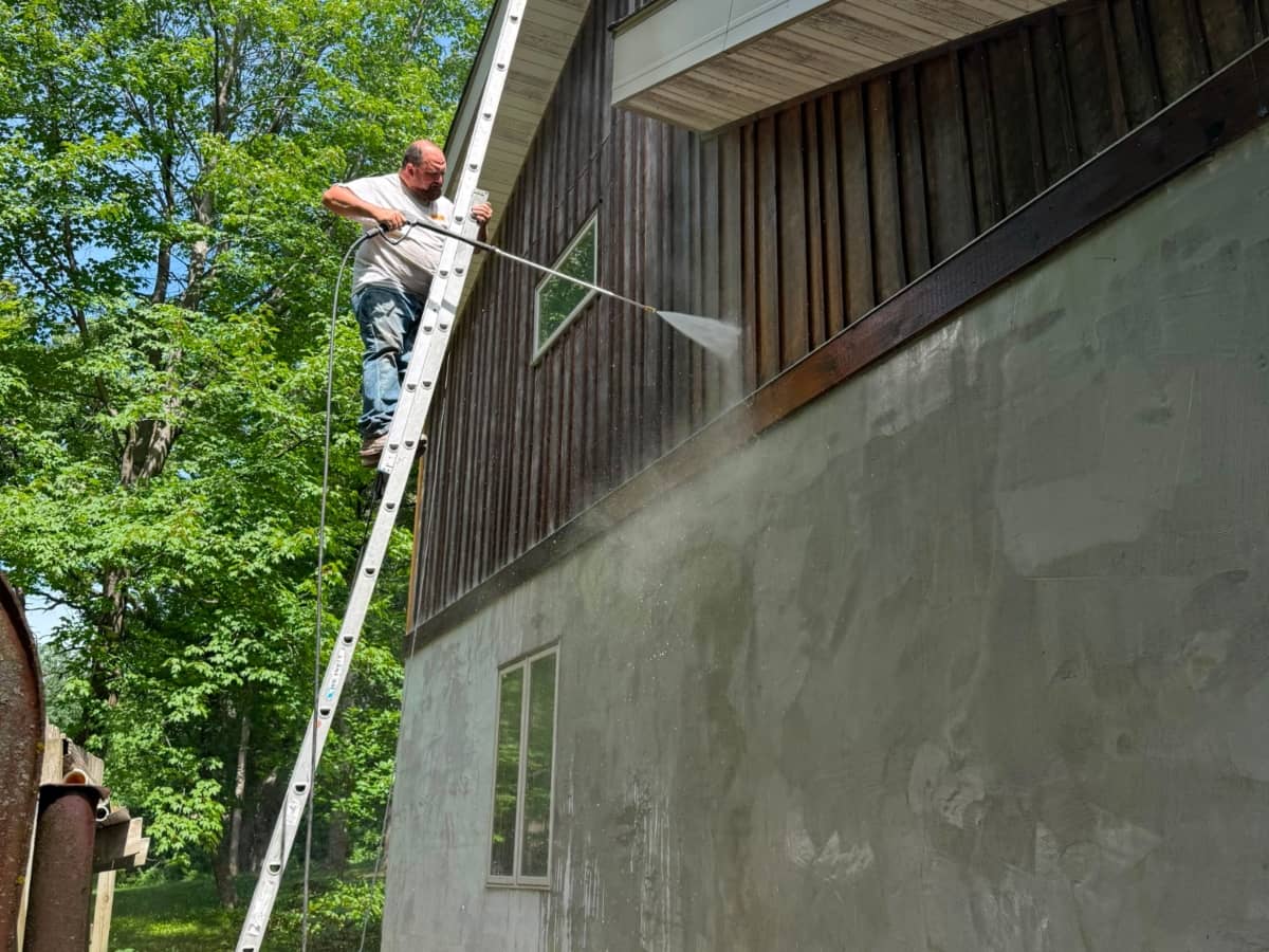 Pressure washing home siding before painting